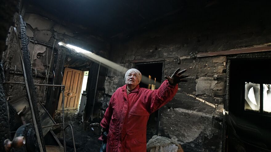 A woman in a burned-out house after shelling