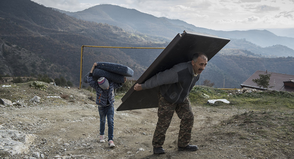 Paradise Lost. Murad Mvrgaryan and his son Vahak carry items from their home before leaving the town of Lachin, Nagorno-Karabakh.
