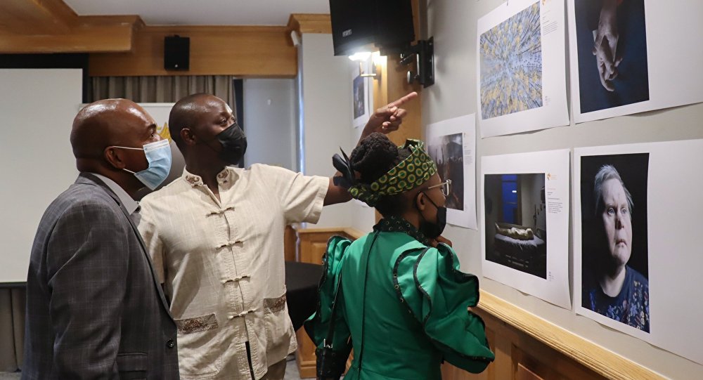 Visitors look at photos during the opening ceremony of the Stenin Photo Contest exhibition in Pretoria, South Africa.